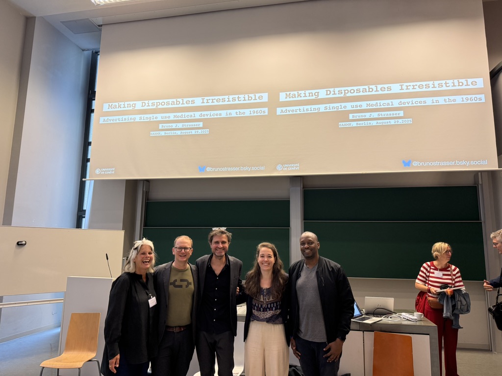 After the Single Use researchers stand together in front of a presentation screen in a conference room.