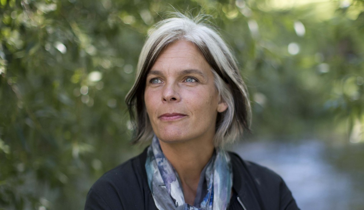 Anne Kveim Lie press shot with a leafy bright background.