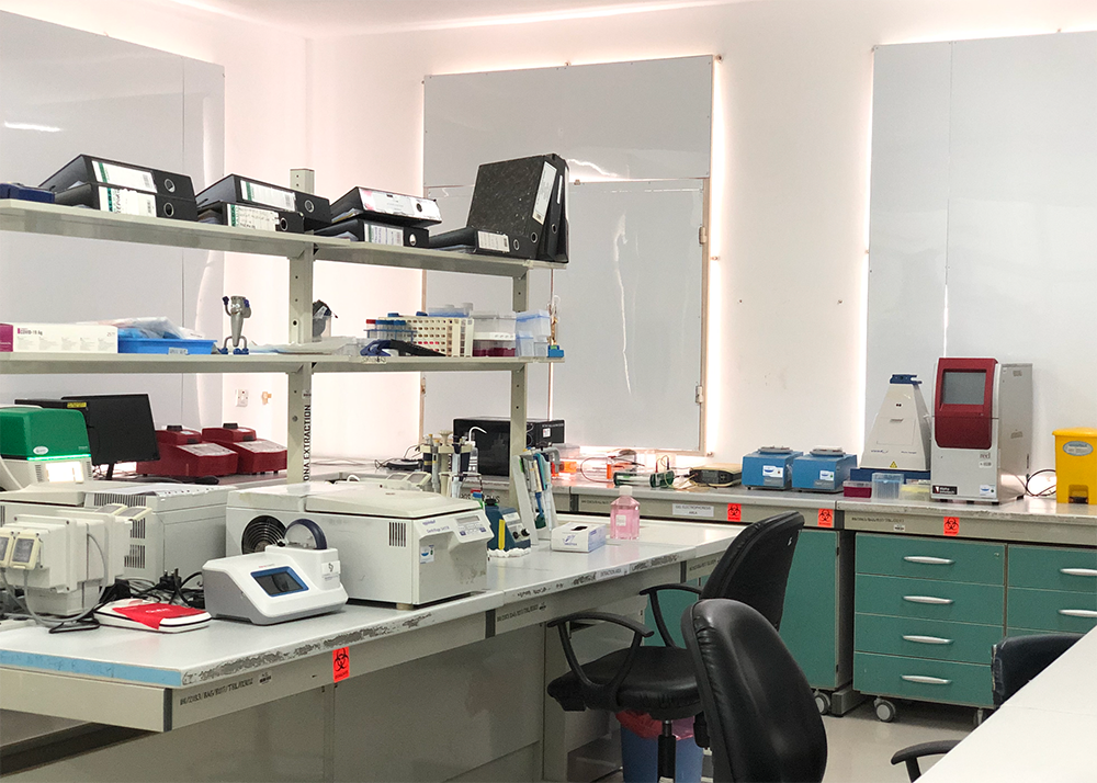 A medical testing room with various apparatus white white walls and blinds over the windows.