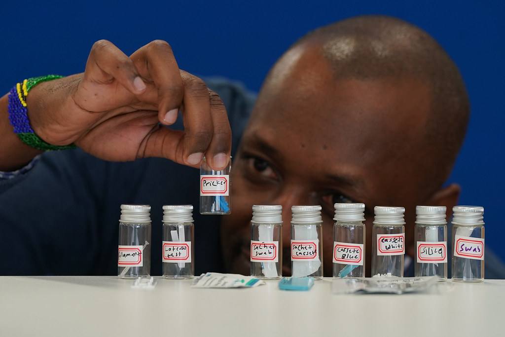 A row of test tubes containing components of a deconstructed Malaria RDT kit.
