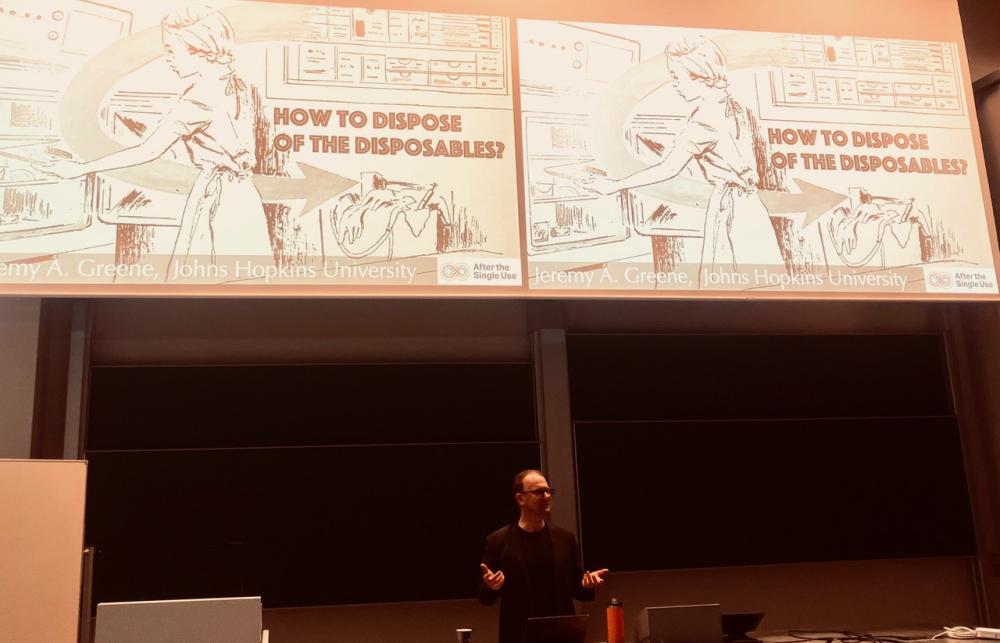 Jeremy presenting his paper with a historical image on the screen behind him