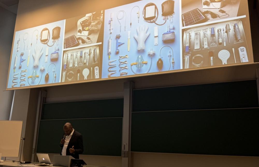 Peter presenting his paper with images of single-use devices on the screen behind him