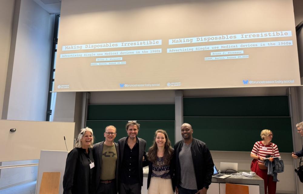 After the Single Use researchers stand together in front of a presentation screen in a conference room. 