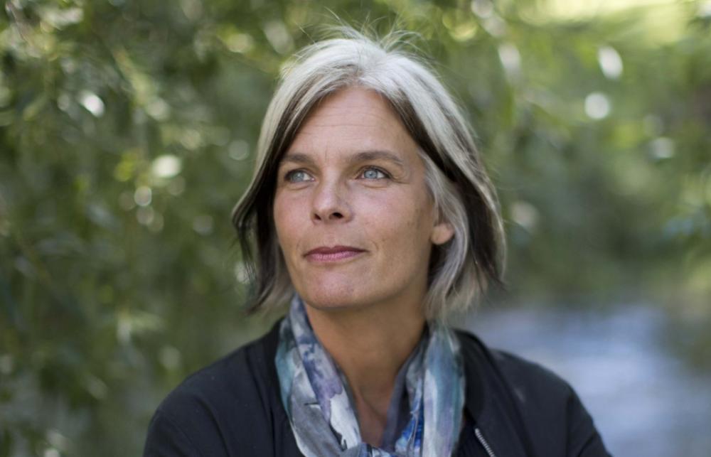 Anne Kveim Lie press shot with a leafy bright background. 